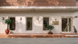 The façade of the Zwaan Boutique with large display windows and a door decorated with plants and minimalist elements; Copyright: Eshita Marwah